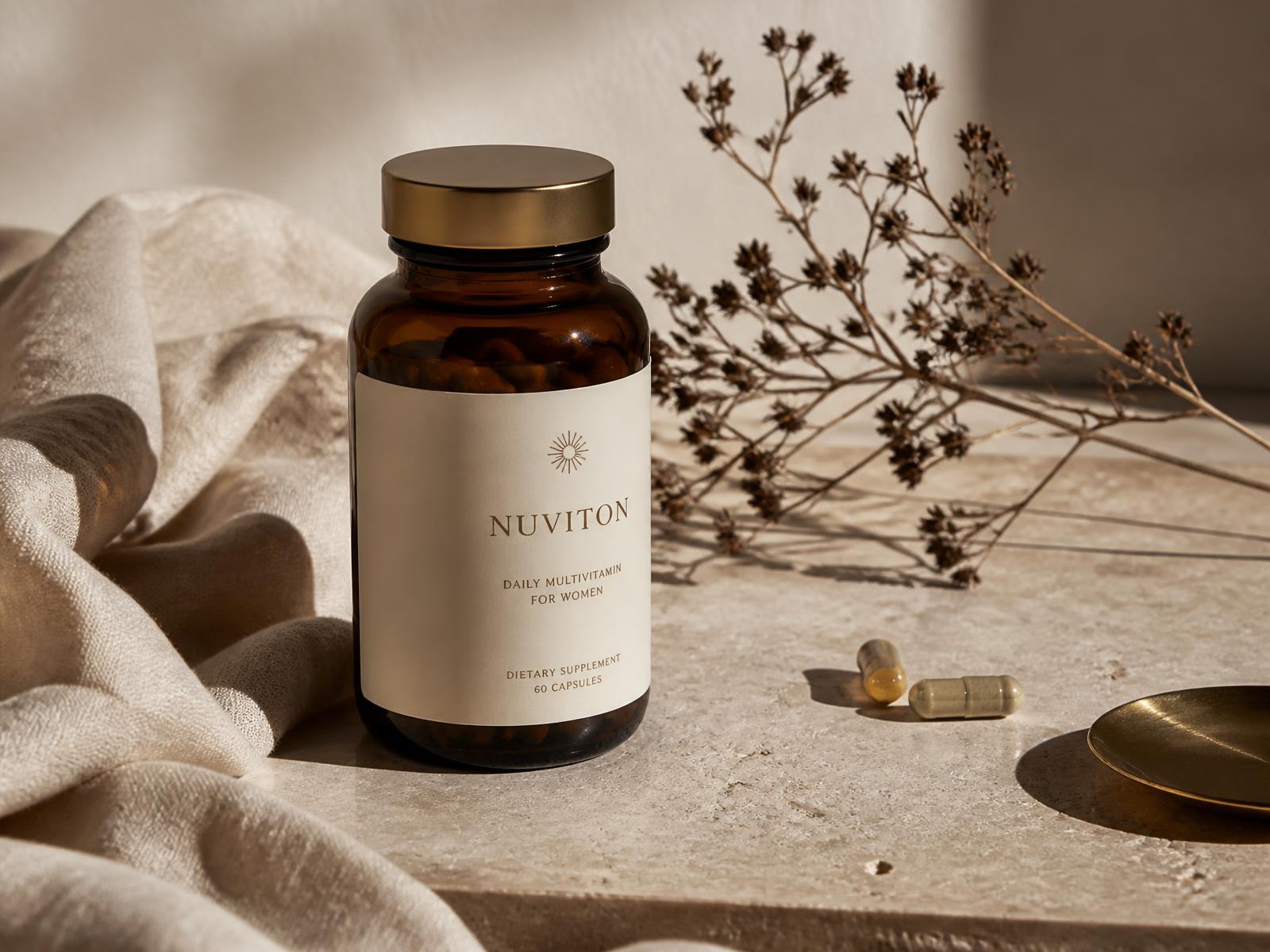 Amber glass NutraMora supplement bottle on travertine with soft morning light